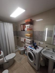 uma casa de banho com uma máquina de lavar roupa e um lavatório em Comfort em Adeje