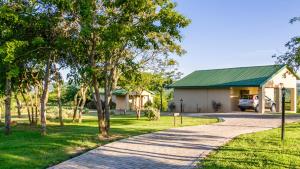 a driveway leading to a house with a green roof at Cuckoo Ridge Country Retreat in Hazyview