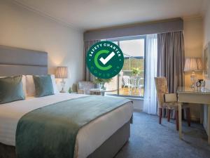 una camera d'albergo con un letto e un grande orologio di HYDE Hotel a Galway