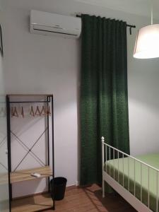 ノートにあるCrocifisso appartamentのベッドルーム(緑のカーテン、ベビーベッド付)