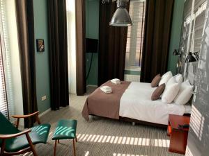 1 dormitorio con 1 cama con paredes y sillas verdes en Hotel Nijver en Geldrop