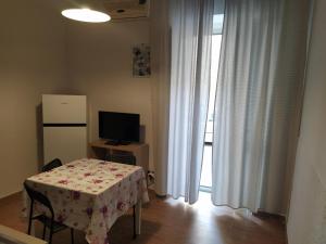 ノートにあるCrocifisso appartamentのテーブル、テレビ、窓が備わる客室です。
