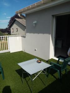 d'une terrasse avec une table et des chaises sur gazon. dans l'établissement Chez patou, à Jezainville