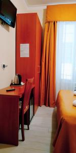 sypialnia z biurkiem, łóżkiem i oknem w obiekcie Hotel Everest w Rzymie