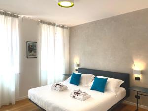 sypialnia z łóżkiem z niebiesko-białymi poduszkami w obiekcie Bed's Apartments w mieście Soave