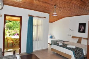 een slaapkamer met 2 bedden, een tafel en een raam bij San Simon Hotel in Cıralı