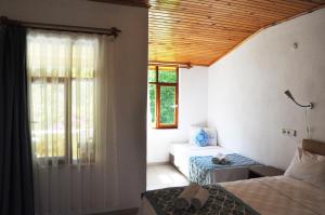 een kamer met 2 bedden en een raam en een bed sidx sidx sidx bij San Simon Hotel in Cıralı