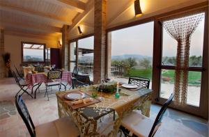 a dining room with a table and chairs and windows at Colle Regnano in Tolentino