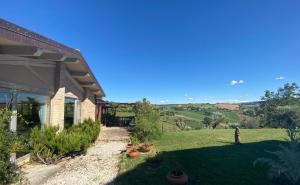 a house with a view of a yard with plants at Colle Regnano in Tolentino