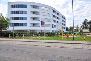 un grande edificio bianco sul lato di una strada di Apartament CASA BIANCA a Kołobrzeg