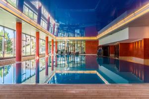 a large swimming pool in a building with a large window at Apartment Enzian mit Mitbenutzung SPA & Wellness - GRIWA RENT AG in Beatenberg