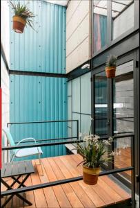 einen Balkon mit zwei Topfpflanzen und einem Stuhl in der Unterkunft Cozy Loft with Balcony in Mexiko-Stadt