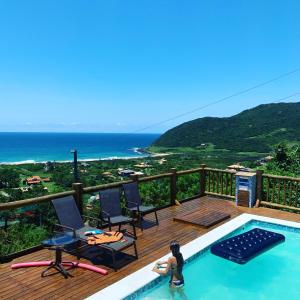 une femme assise dans une piscine sur une terrasse dans l'établissement Pousada Moradas da Silveira, à Garopaba