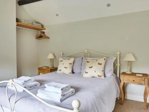 a bedroom with a bed with towels on it at Lilly Cottage in Lydney