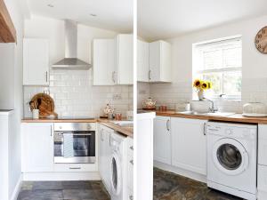 a kitchen with white cabinets and a washer and dryer at Lilly Cottage in Lydney