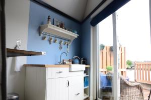 a kitchen with blue walls and a white cabinet at Froukje's B&B in Woerdense Verlaat
