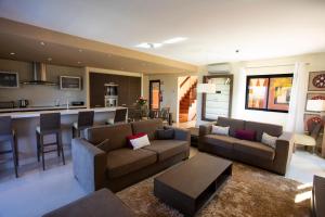a living room with two couches and a kitchen at Amendoeira Golf Resort in Armação de Pêra