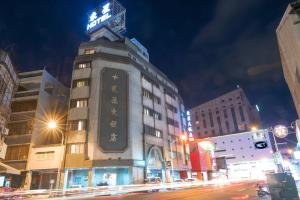 um edifício com um sinal em cima dele à noite em Tong Hsin Hotel em Pingtung City