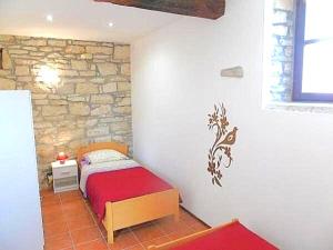 a bedroom with a bed and a stone wall at Villa Rustica in Buje +21 photos