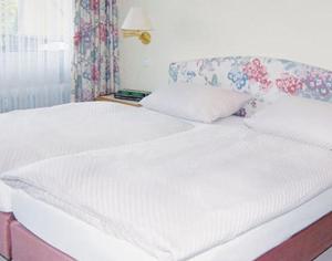 a large white bed in a room with a window at Ferienwohnung Haus Schiller in Königsfeld im Schwarzwald