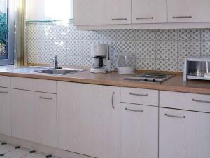 a kitchen with white cabinets and a counter top at Ferienwohnung Haus Schiller in Königsfeld im Schwarzwald