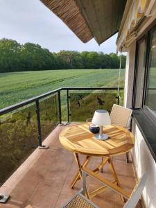 a wooden table on a balcony with a view of a field at Pension Petersen in Bergen auf Rügen