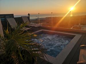 een hot tub bovenop een gebouw met een zonsondergang bij Diamond Townhouse 17 in Paphos City