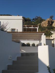 una escalera que conduce a una casa blanca con una escalera en Psathaki, en Kimolos