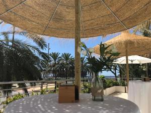 
a large umbrella sitting on top of a sandy beach at Ohtels Gran Hotel Almeria in Almería
