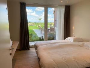 een slaapkamer met een groot bed en een groot raam bij In 't Groen in Watou