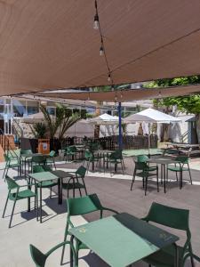 Un patio al aire libre con mesas, sillas y sombrillas. en Camping San Javier, en San Javier