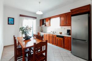 パルガにあるVilla Matinaのキッチン(木製テーブル、ステンレス製の冷蔵庫付)