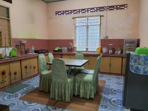 a kitchen with a table and chairs in a kitchen at Homestay Bonda in Kampong Amir