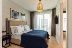 a hotel room with a bed and a large window at Kaya Palazzo Resort & Residences Le Chic Bodrum in Bodrum City