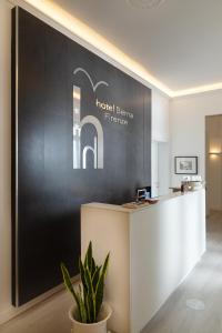 a reception area of a hotel with a black wall at Hotel Berna in Florence