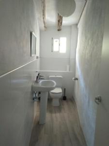 een witte badkamer met een wastafel en een toilet bij Casa Flor de lis in Herce
