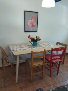 a table with chairs and a table with flowers on it at Casa Flor de lis in Herce