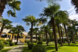 uma fila de palmeiras em frente a um edifício em Hotel Savoia Thermae & SPA em Abano Terme