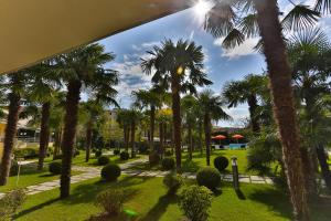 vista su un parco con palme e erba di Hotel Savoia Thermae & SPA ad Abano Terme