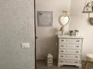 sypialnia z białą komodą i lustrem w obiekcie Casa vacanze I PINI E IL CILIEGIO w mieście Pale