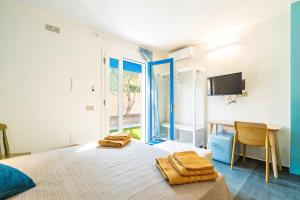 1 dormitorio con 1 cama, escritorio y TV en Affittacamere Resort Beach San Gemiliano, en Àrbatax