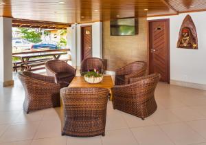 a dining room with a table and wicker chairs at Quinta do Sol Lite Praia Hotel in Porto Seguro