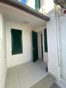 a room with green doors and white walls at villetta sul mare Rachele in Marina di Campo
