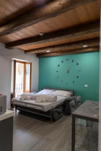ein Schlafzimmer mit einem Bett mit einer Uhr an der Wand in der Unterkunft Dimora Domese in Domodossola