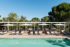 a swimming pool with lounge chairs and umbrellas at Les Maisons Du Sud in Saint-Tropez