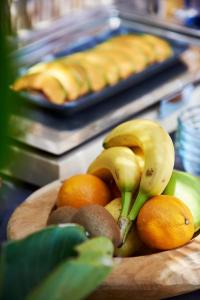 a bowl of fruit on a table with bananas and oranges at Les Maisons Du Sud in Saint-Tropez