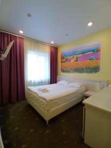 - une chambre avec un lit et une peinture murale dans l'établissement VEGA Hotel, à Arkhangelsk