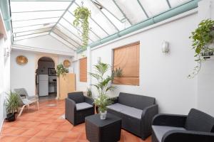 a conservatory with couches and chairs and a glass ceiling at Pensión Zacatin in Granada