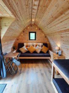 um quarto com um sofá numa pequena casa em Bwlcheinion Sea View Glamping em Machynlleth