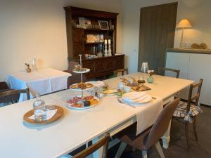 een eetkamer met een tafel met eten erop bij In 't Groen in Watou